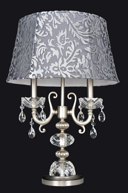 3.6 Light Table Lamp. The Haydn Collection merges modern style with traditional acanthus leaves. An ornate stem and elegant curves in Aged Bronze or Antique Brass are crowned with Clear Firenze bobeches, while dangling crystals add sparkle and glamour.